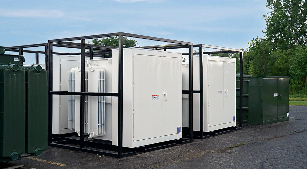 White JCL rental padmounts in shipping frames staged in the yard